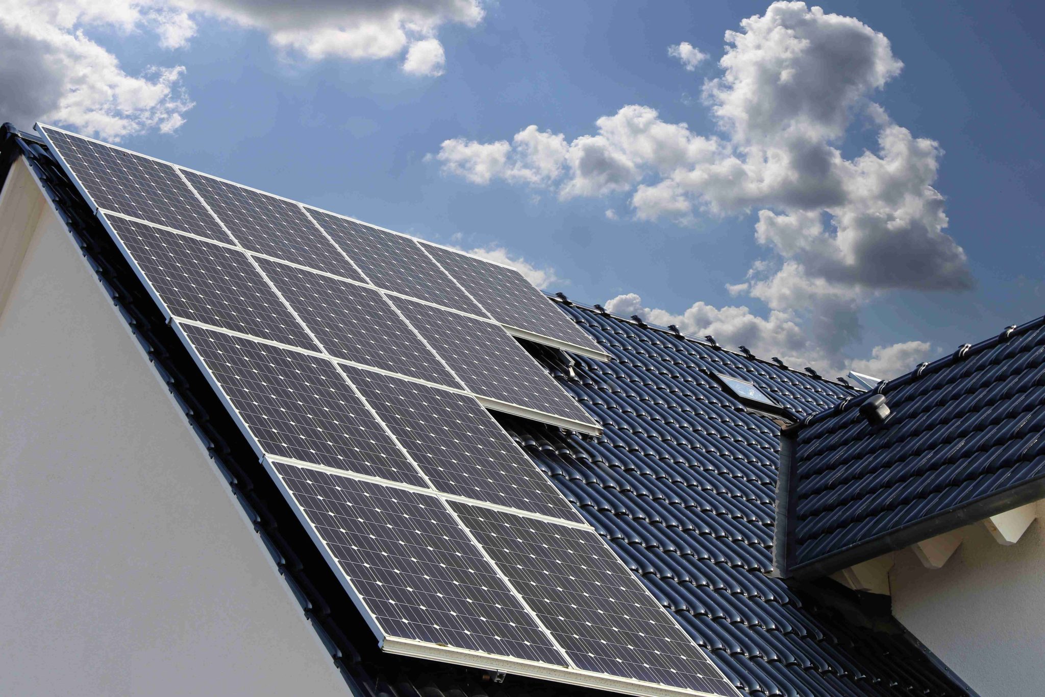Maison équipée de panneaux solaires et batterie de stockage, symbole d’autoconsommation énergétique.