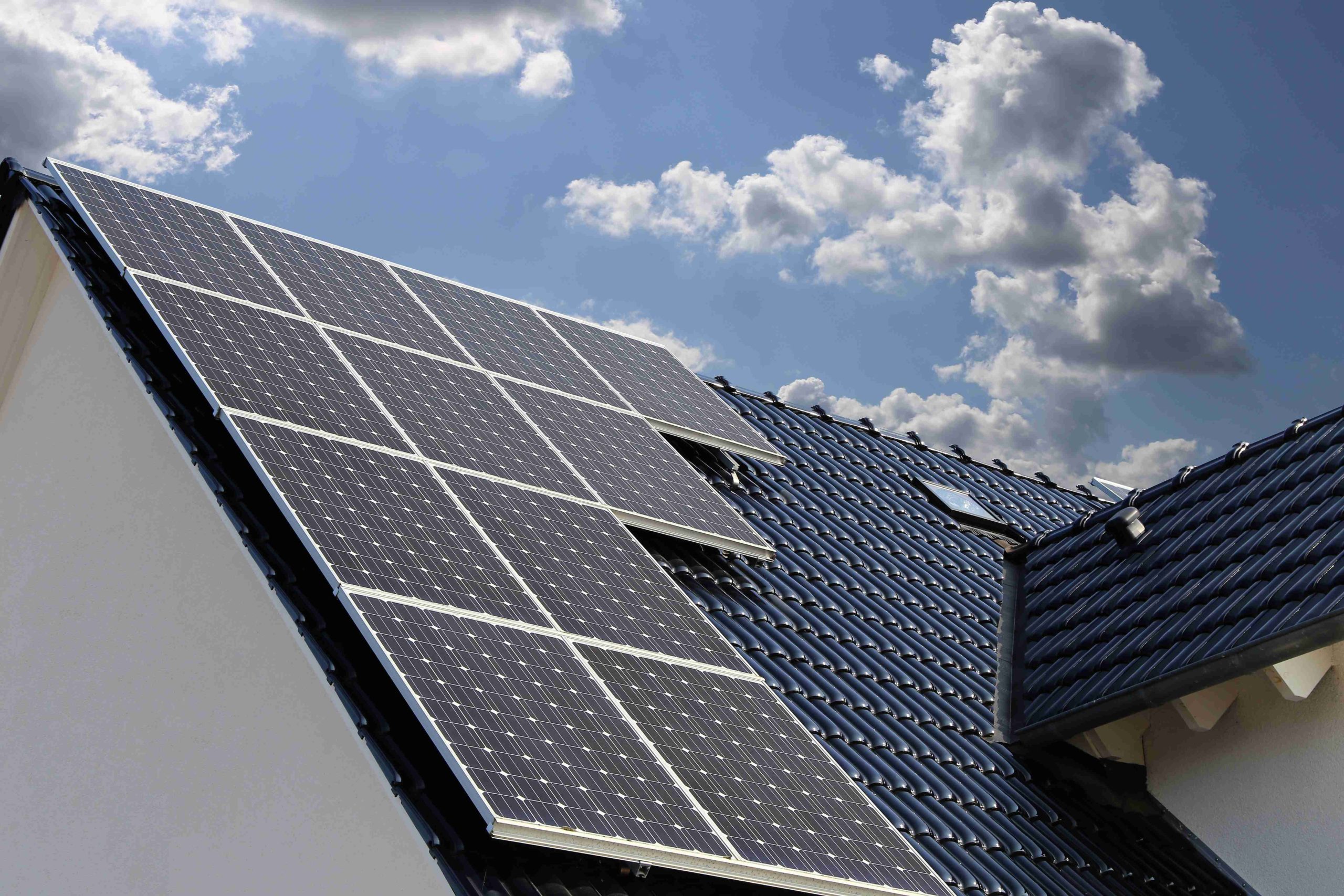 Maison équipée de panneaux solaires et batterie de stockage, symbole d’autoconsommation énergétique.